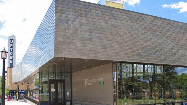 Walker Library in Uptown Minneapolis, a modern Hennepin County Library building with large windows and the Uptown sign visible in the background.